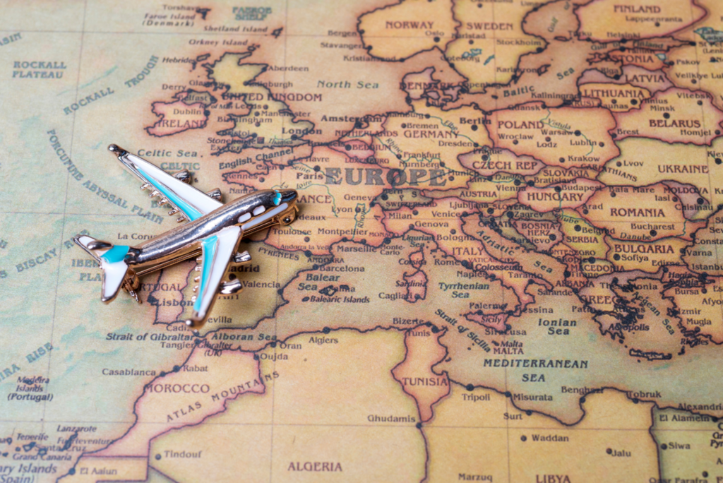 Un avion miniature sur une carte de l’Europe, symbolisant les possibilités de rencontres en France et à l’international avec Elite Connexion.