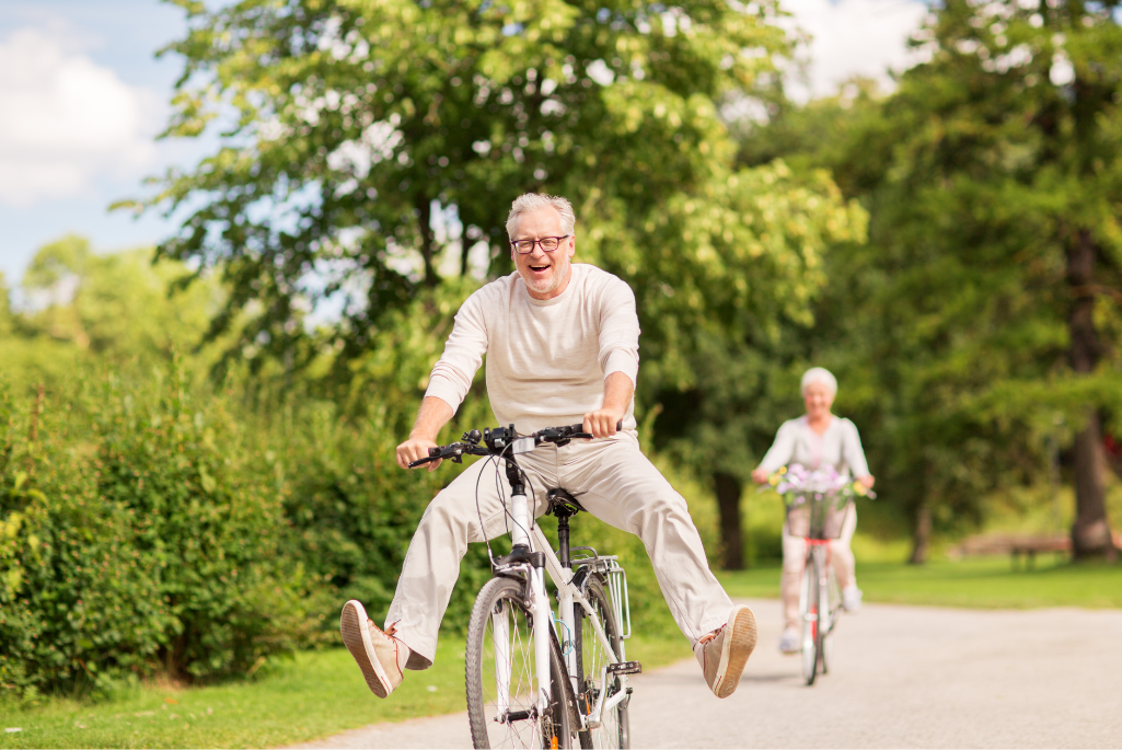 Des seniors faisant du vélo avec enthousiasme dans un parc.